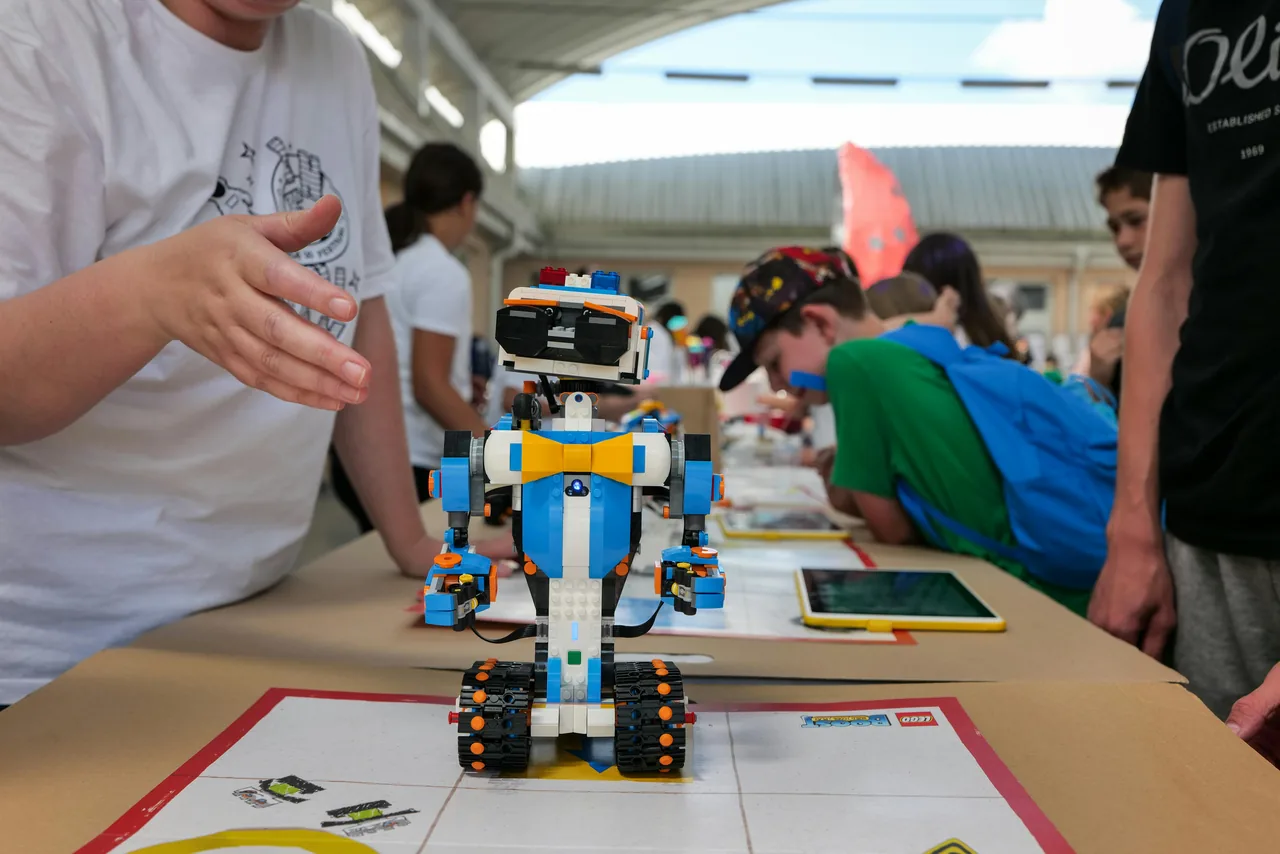 Kids showing a robotics project at a learning event